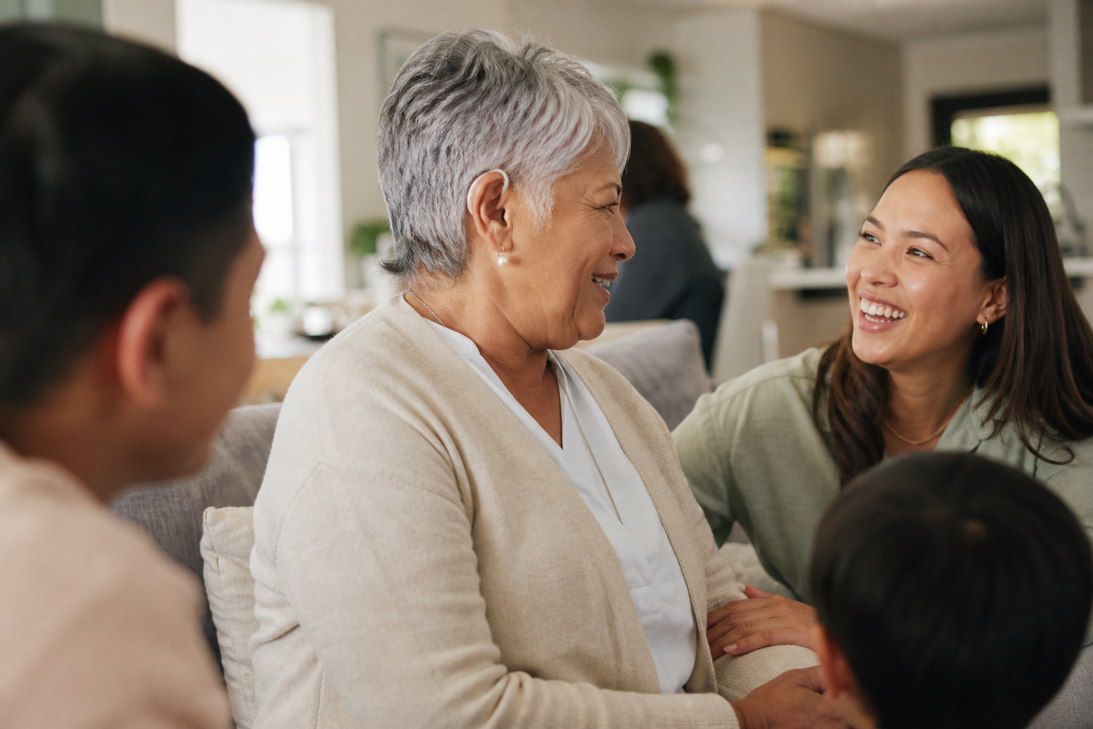 Older adult wearing a discreet hearing aid while enjoying a family conversation